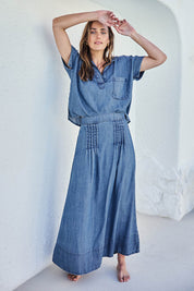 Model Tegand wearing size 10 of the Perfect Day Pleat Detail Lyocell Maxi Skirt – Denim in colour Denim, from the front