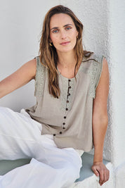 Model Tegand wearing size 10 of the Cute As A Button Fringed Tank – Stone in colour Stone, in a cropped view