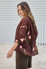 Model Tegand wearing size 10 of the I Can Buy Myself Flowers Blouse – Wine in colour Wine, from an angle