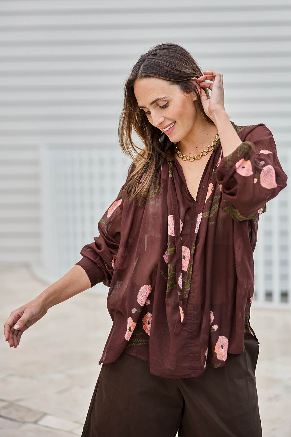 Model Tegand wearing size 10 of the I Can Buy Myself Flowers Blouse – Wine in colour Wine, in a cropped view