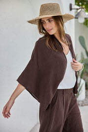 Model Tegand wearing size 10 of the Out Of Office Woven Cotton Shrug  - Chocolate in colour Chocolate, from an angle