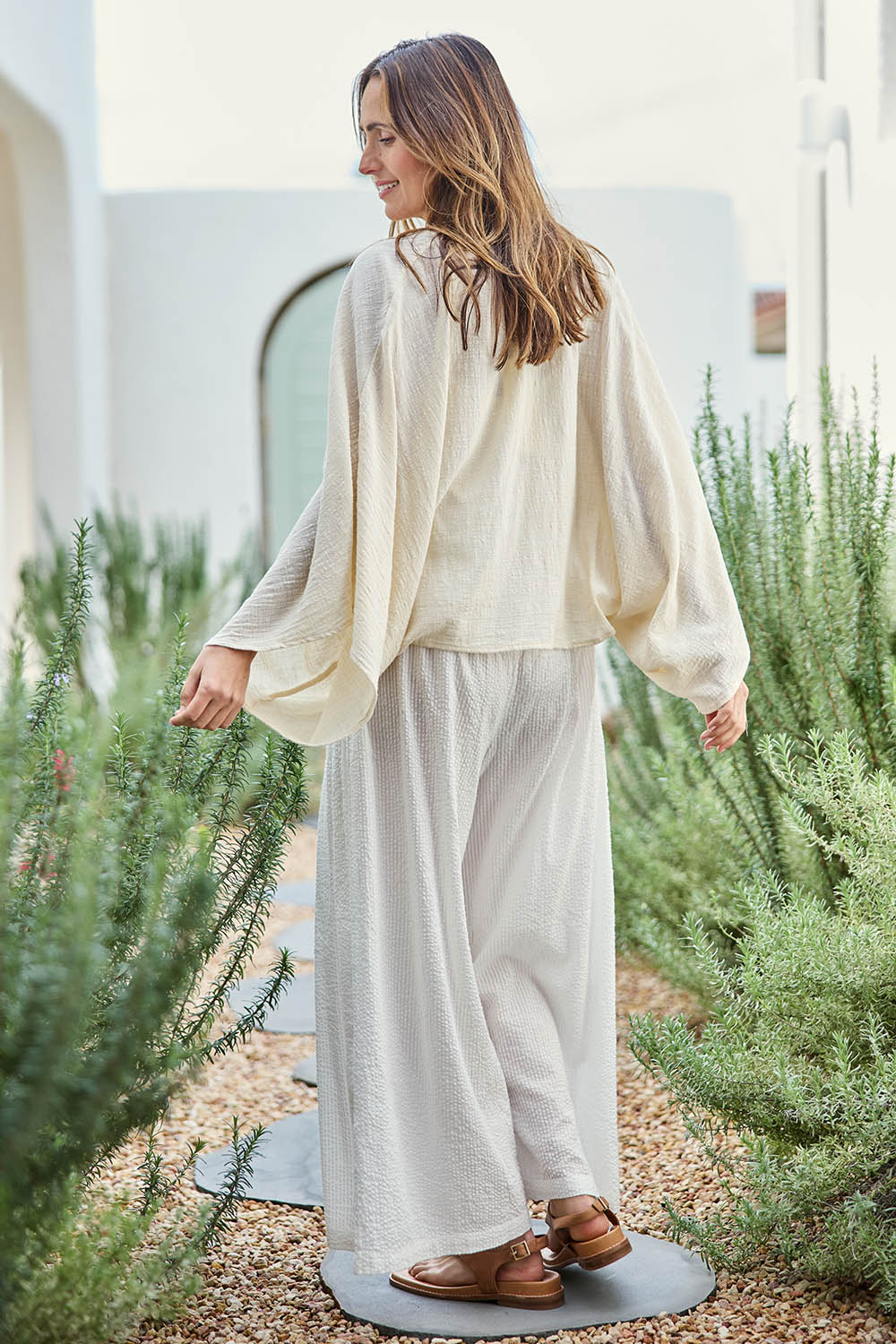 Model Tegand wearing size 10 of the Out Of Office Woven Cotton Shrug  - Sand in colour Sand, from the front