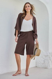 Model Tegand wearing size 10 of the Out Of Office Woven Cotton Longline Shorts - Chocolate in colour Chocolate, from the front