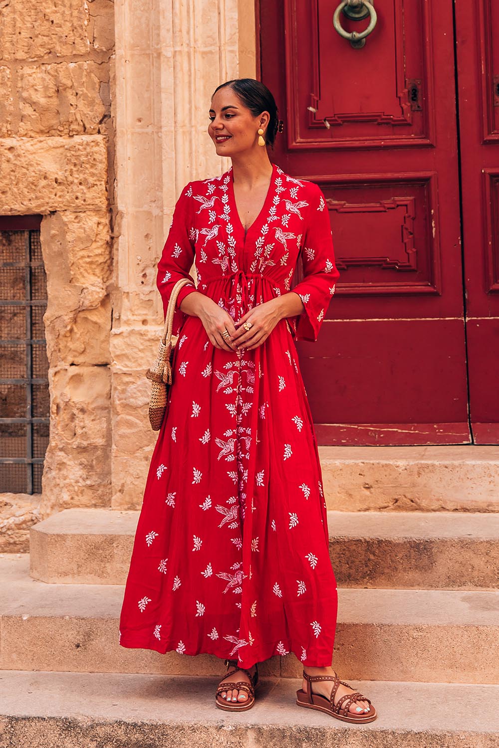 A model wearing the Dancing With Birds Dress in colour Scarlet (Red), from the front, showing the whole outfit