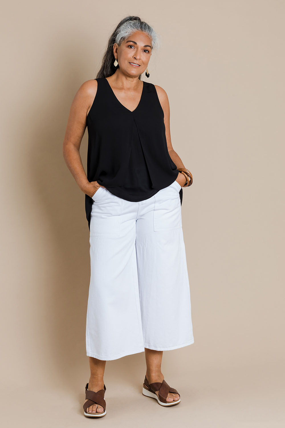 Model Nadine wearing size 10 of the Sugar Snaps Layers Tank in colour Black (Black), from the front, showing the whole outfit