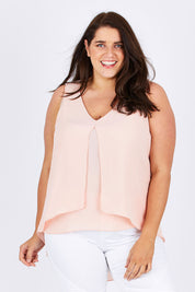 Model Mae wearing size 18 of the Sugar Snaps Layers Tank in colour PeachyKeen (Pink), from the front, cropped image