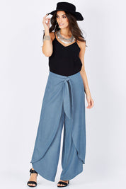 Model Georgia wearing size 10 of the Wrapped In You Pants in colour Denim (Blue), from the front, showing the whole outfit