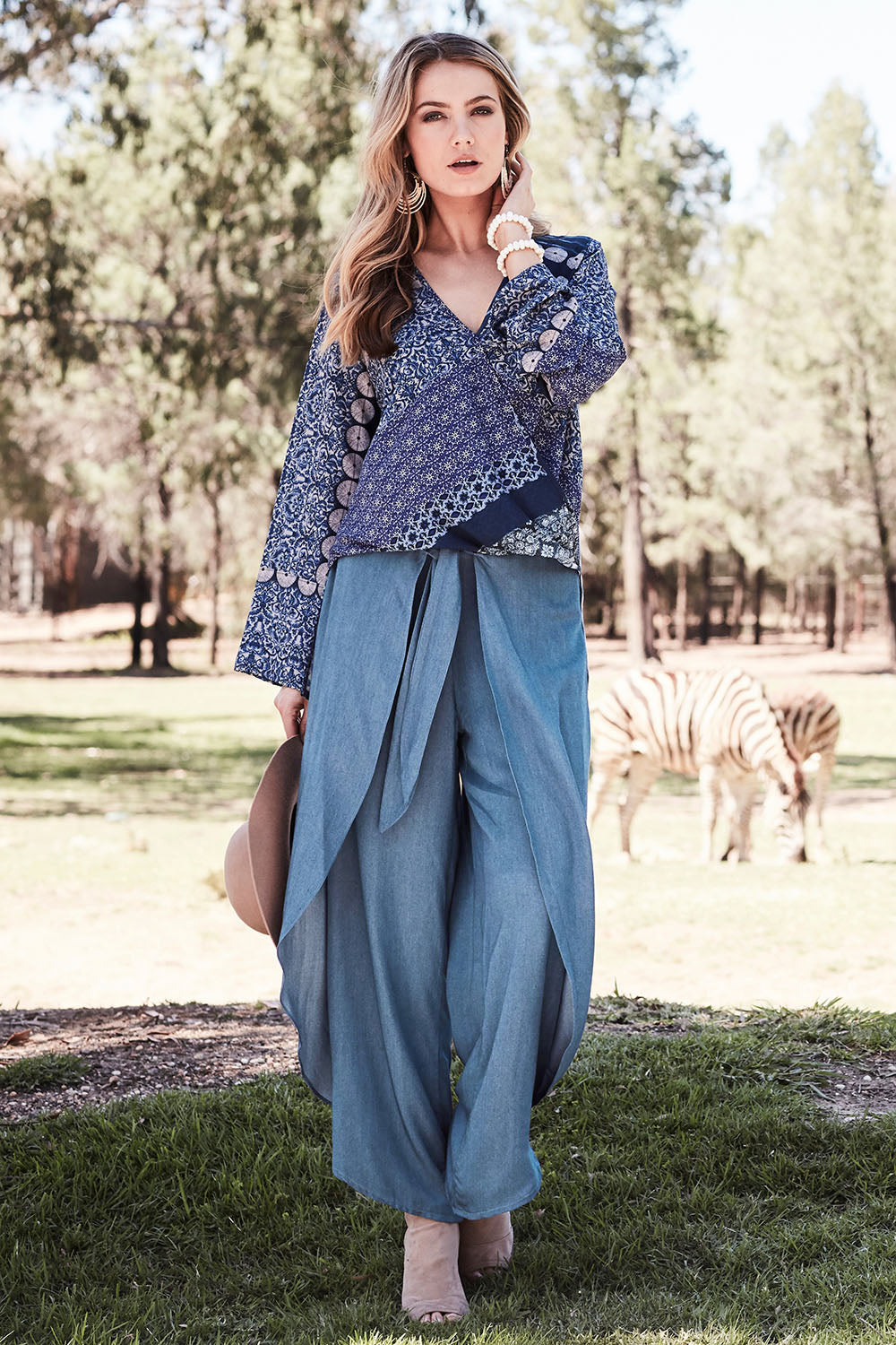 Model Marnee wearing size 10 of the Wrapped In You Pants in colour Denim (Blue), from the front, showing the whole outfit