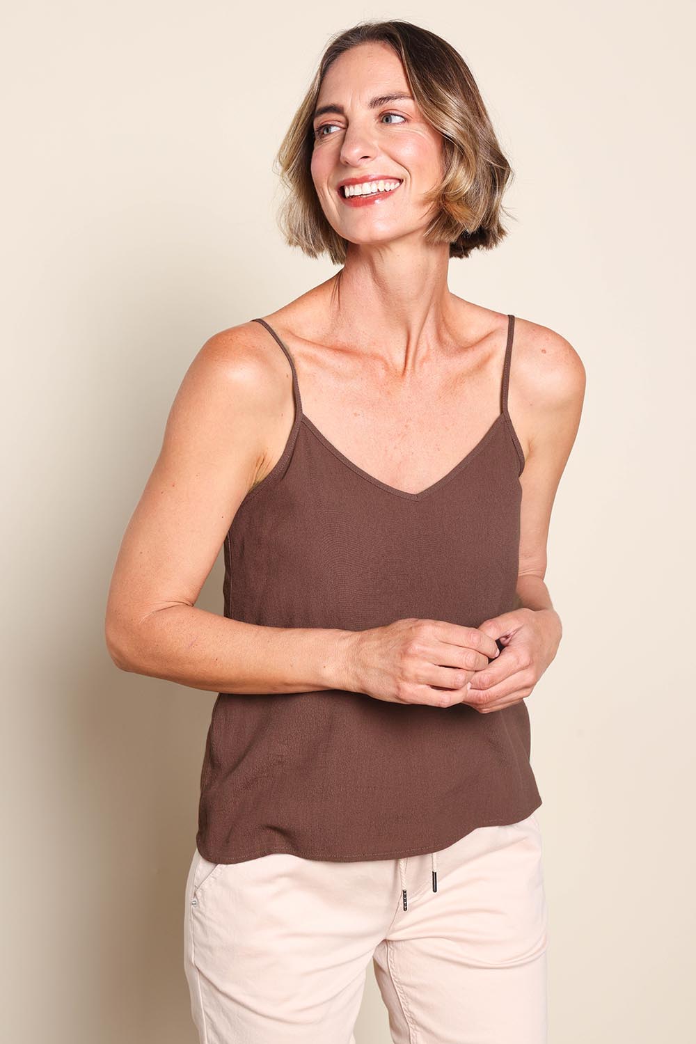 Model Riinar wearing size 10 of the Runaway Top – Chocolate in colour Chocolate, in a cropped view