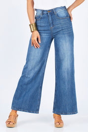 Model Gemma wearing size 10 of the Happy Me Wide Leg Jeans in colour Denim (Blue), from the front, cropped image