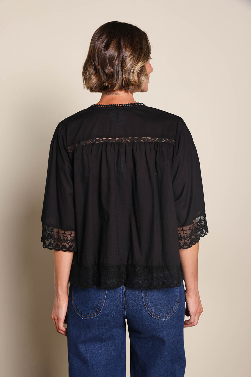 Model Riinar wearing size 10 of the Spring Day Cotton Throw - Black in colour Black, from the back