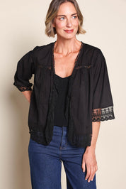 Model Riinar wearing size 10 of the Spring Day Cotton Throw - Black in colour Black, in a cropped view