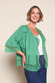 Model Riinar wearing size 10 of the Spring Day Throw – Green in colour Green, in a cropped view