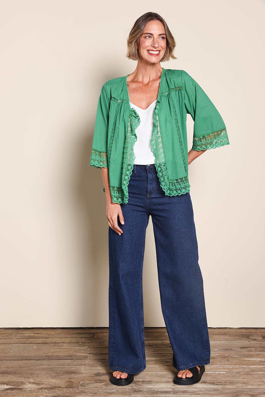 Model Riinar wearing size 10 of the Spring Day Throw – Green in colour Green, from the front