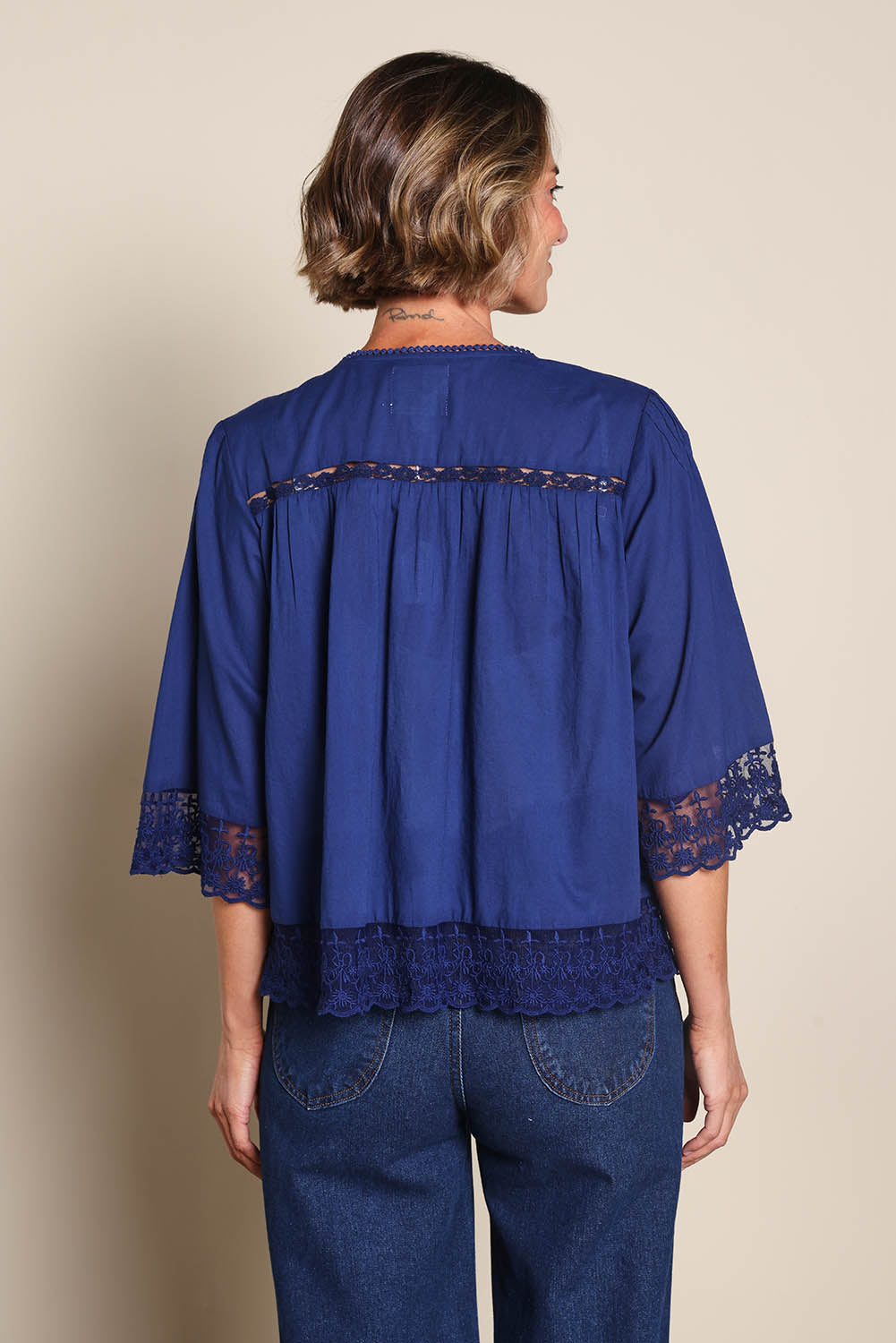 Model Riinar wearing size 10 of the Spring Day Throw – Navy in colour Navy, from the back