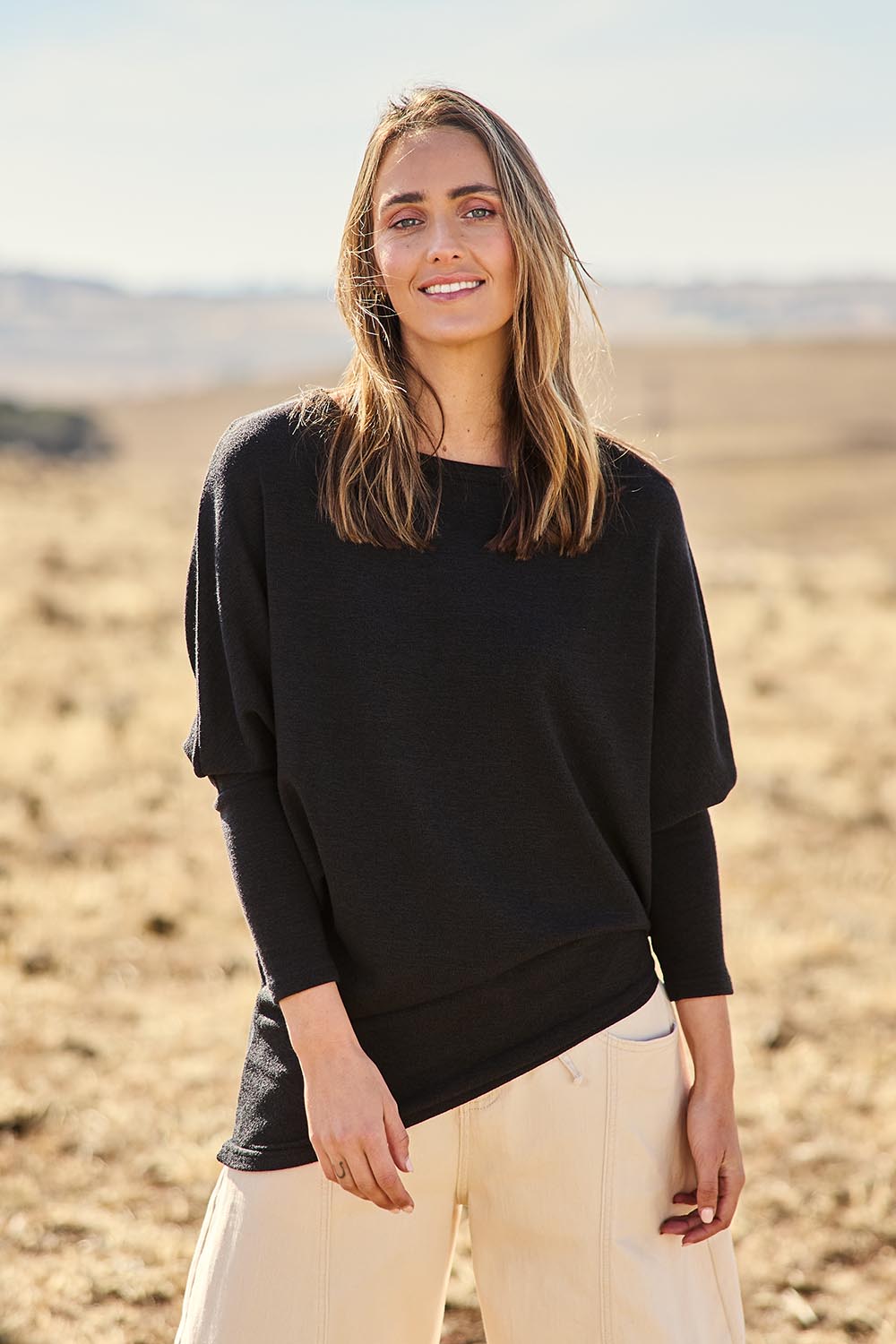 Model Nat wearing size 10 of the Snuggle Up Jumper in colour Black (Black), from the front, showing the whole outfit