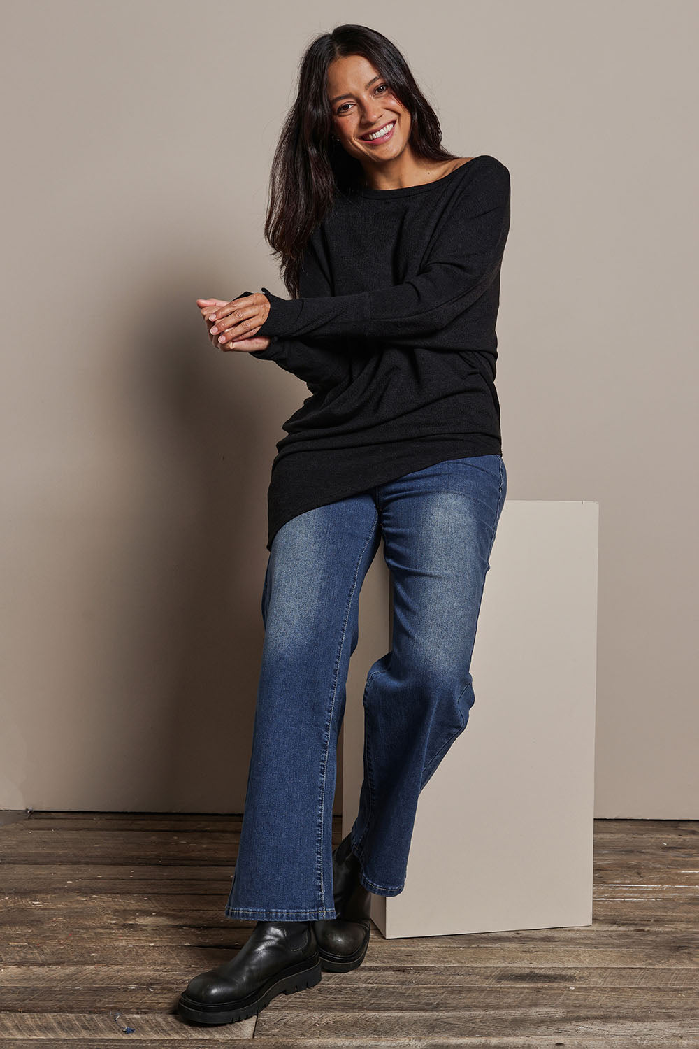 Model Tahnee wearing size 10 of the Snuggle Up Jumper in colour Black (Black), from the front, showing the whole outfit