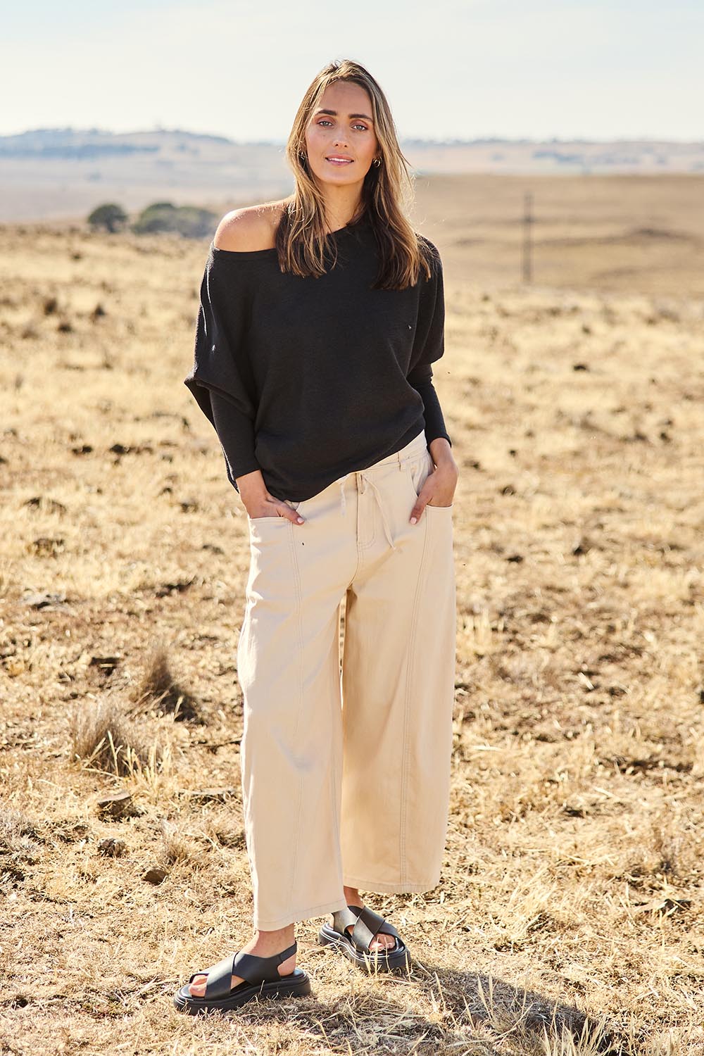 Model Tegan wearing size 10 of the Snuggle Up Jumper in colour Black (Black), from the front, showing the whole outfit