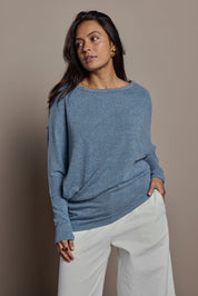 Model Tahnee wearing size 10 of the Snuggle Up Jumper in colour Denim (Blue), from the front, cropped image