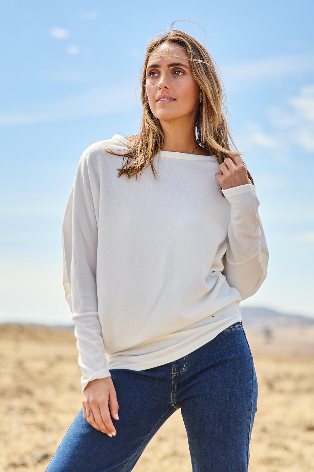 Model Tegan wearing size 10 of the Snuggle Up Jumper in colour Ivory (White), from the front, showing the whole outfit