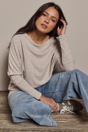 Model Tahnee wearing size 10 of the Snuggle Up Jumper in colour Sandmarl, from the front, showing the whole outfit