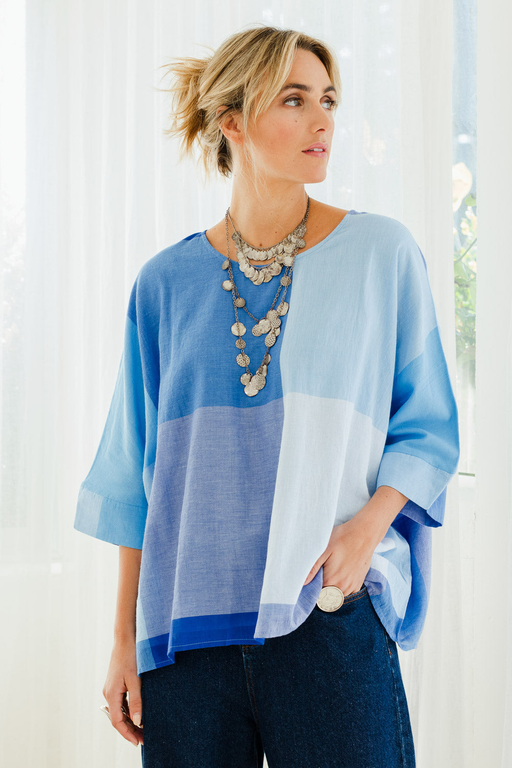 Model Tegan wearing size 10 of the Joy And Laughter Slouch Top in colour Blues (Blue), from the front, showing the whole outfit