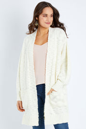 Model Elhana wearing size S of the Mountain Dreaming Cardi in colour Cream (White), from the front, cropped image