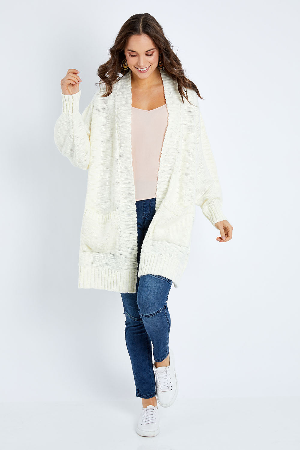 Model Elhana wearing size S of the Mountain Dreaming Cardi in colour Cream (White), from the front, showing the whole outfit