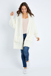 Model Elhana wearing size S of the Mountain Dreaming Cardi in colour Cream (White), from the front, showing the whole outfit