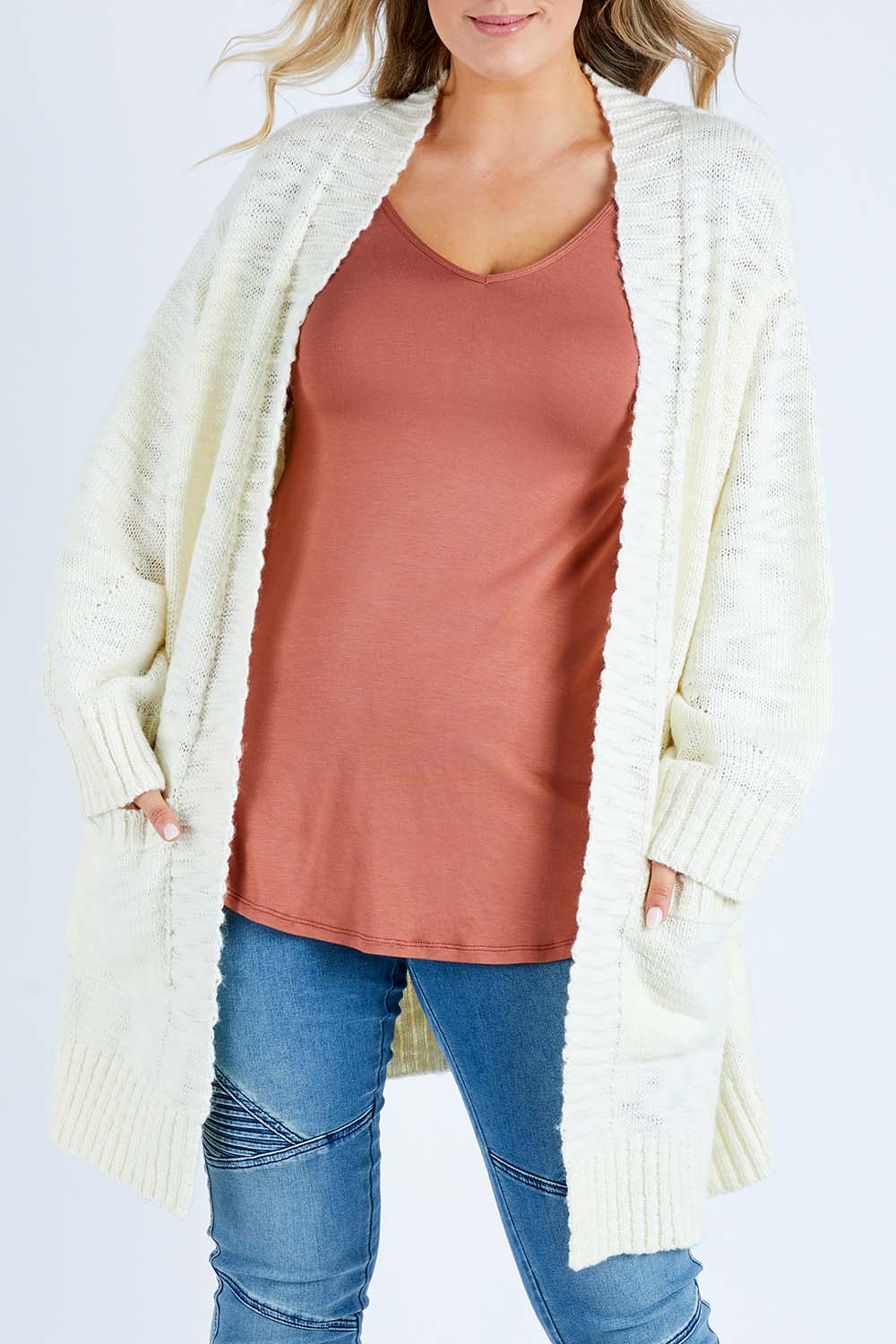 Model Jess wearing size L of the Mountain Dreaming Cardi in colour Cream (White), from the front, cropped image