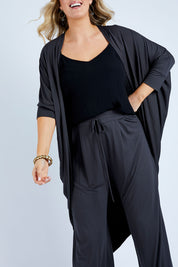 Model Jess wearing size 14 of the Falling For You Bamboo Cardi in colour Storm (Black), from the front, cropped image
