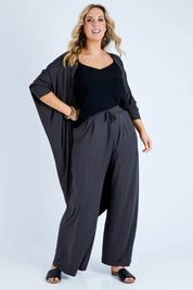 Model Jess wearing size 14 of the Falling For You Bamboo Cardi in colour Storm (Black), from the front, showing the whole outfit