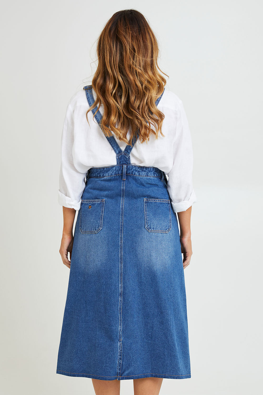 Model Laura wearing size 14 of the Overall Happiness Dress in colour Denim (Blue), from the back