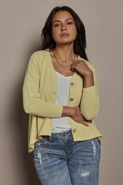 Model Tahnee wearing size 10 of the My Boyfriends Slouch Cardi in colour Butter, from the front, cropped image