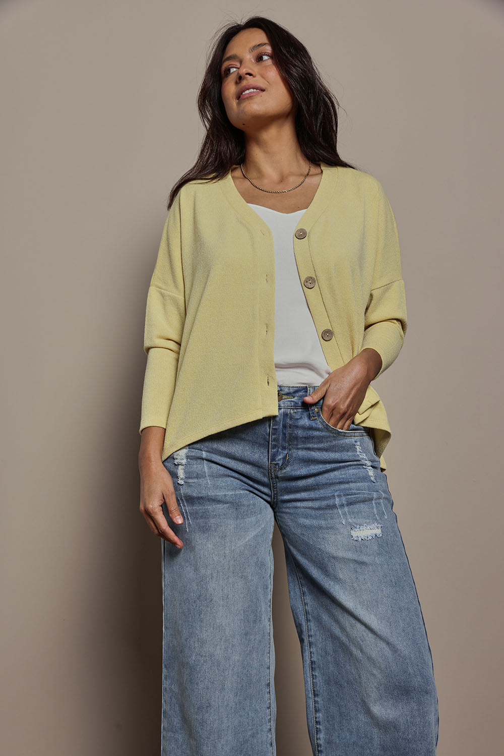 Model Tahnee wearing size 10 of the My Boyfriends Slouch Cardi in colour Butter, from the front, cropped image