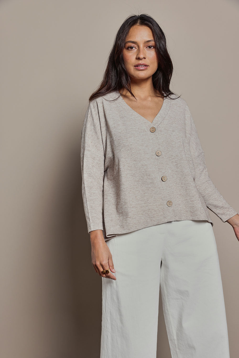 Model Tahnee wearing size 10 of the My Boyfriends Slouch Cardi in colour Sandmarl, from the front, cropped image