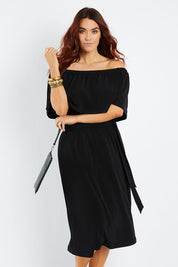 Model Laura wearing size 14 of The Wanderer In Me Off Shoulder Travel Dress in colour Black (Black), from the front, cropped image