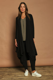 Model Madeline wearing size 10 of The Wanderer In Me Swing Travel Cardi in colour Black (Black), from the front, showing the whole outfit