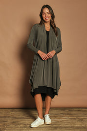 Model Madeline wearing size 10 of The Wanderer In Me Swing Travel Cardi in colour Khaki (Green), from the front, showing the whole outfit
