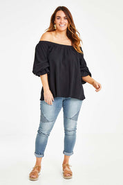 Model Laura wearing size 14 of the Twinkle In My Eye Off The Shoulder Top in colour Black (Black), from the front, showing the whole outfit