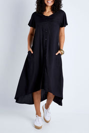 Model Pamela wearing size 10 of the Kiss Me Quick Button Dress in colour Black (Black), from the front, cropped image