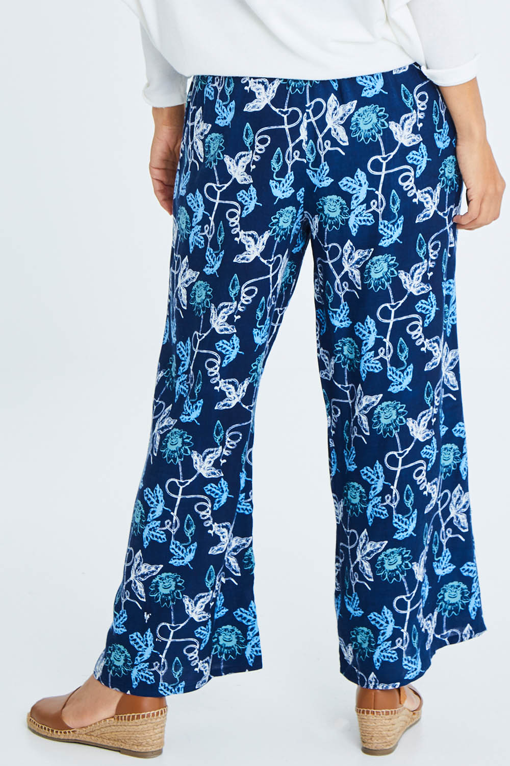 Model Cara wearing size 10 of the My Heart Is Full Flower Pants in colour Deepblue (Blue), from the back