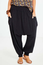 Model Laura wearing size 14 of the Beach Breeze Cotton Slouch Pants in colour Black (Black), from the front, cropped image