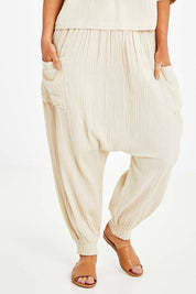 Model Laura wearing size 14 of the Beach Breeze Cotton Slouch Pants in colour Wheat, from the front, cropped image