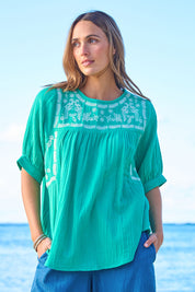 Model Tegan wearing size 10 of the Secret Garden Cotton Blouse in colour Emerald (Green), from the front, showing the whole outfit