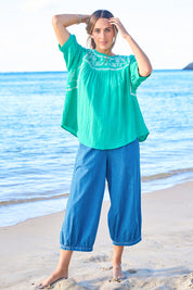 Model Tegan wearing size 10 of the Secret Garden Cotton Blouse in colour Emerald (Green), from the front, showing the whole outfit