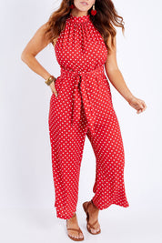 Model Laura wearing size 14 of the Lets Get Festive Jumpsuit in colour Redspot (Red), from the front, cropped image