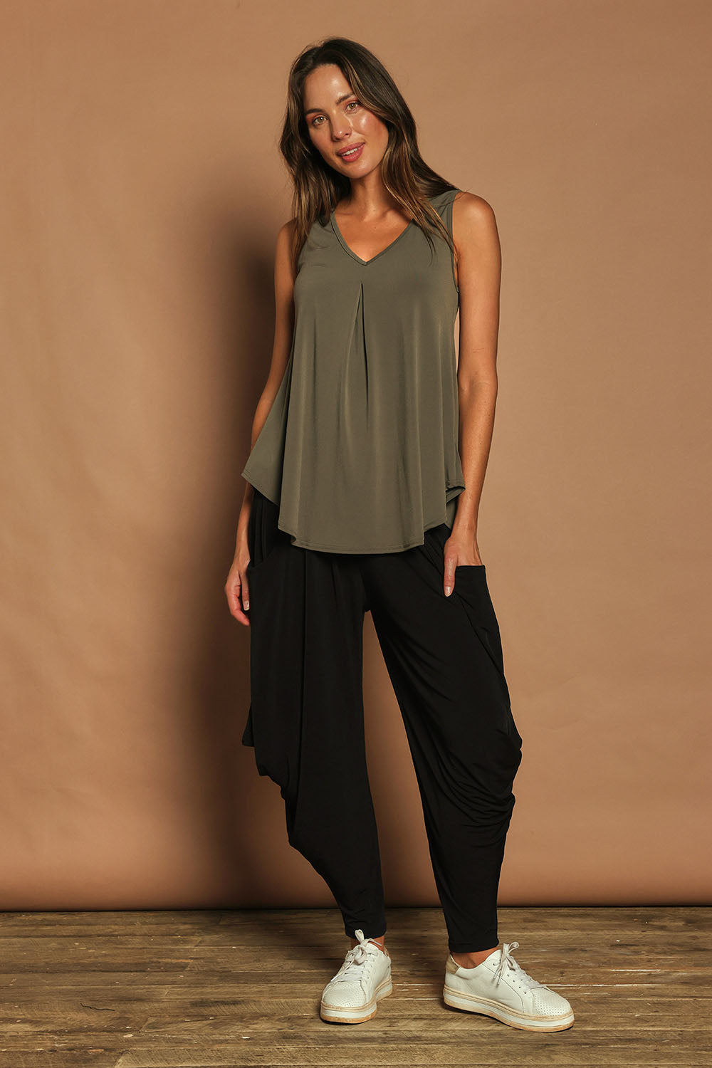 Model Madeline wearing size 10 of The Wanderer In Me V Neck Travel Singlet in colour Khaki (Green), from the front, showing the whole outfit