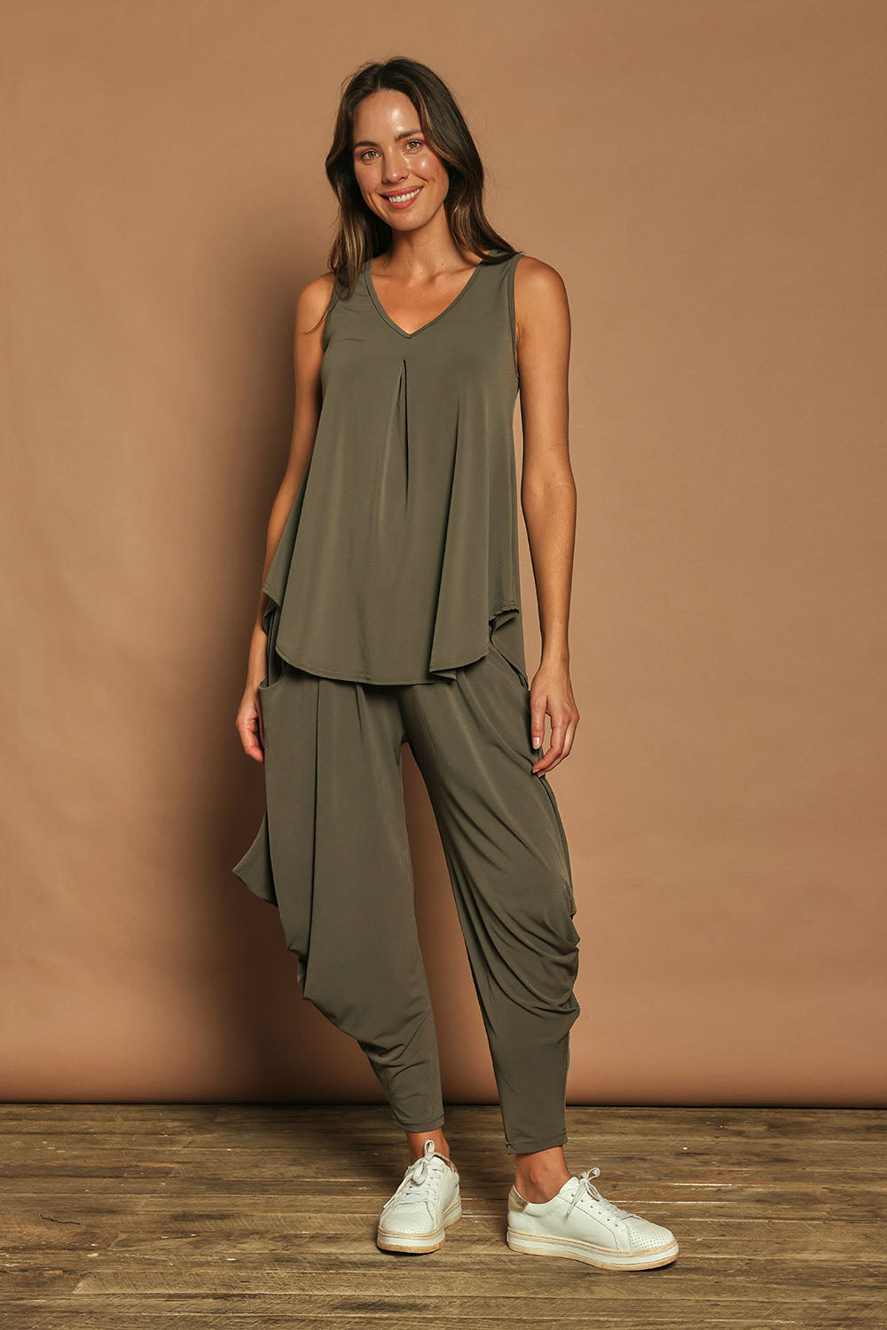 Model Madeline wearing size 10 of The Wanderer In Me V Neck Travel Singlet in colour Khaki (Green), from the front, showing the whole outfit