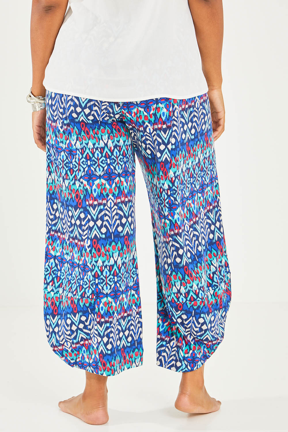 Model Noli wearing size 14 of the Good Vibes Balloon Hem Pants in colour Aztec (Blue), from the back
